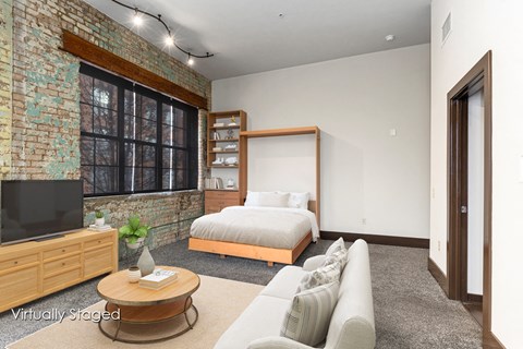 A living room with a brick wall and a television.